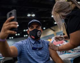 A man takes a selfie as he receives the Johnson and Johnson Covid-19 vaccine at a mass vaccination event at the Puerto Rico Convention Center in San Juan, Puerto Rico on March 31, 2021. (Photo by Ricardo ARDUENGO / AFP) (Photo by RICARDO ARDUENGO/AFP via Getty Images)